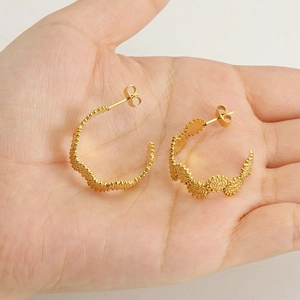 French luxury 18k gold plated stainless steel wave textured hoop earrings on palm