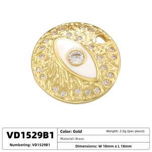 Macro view of a 18mm round golden brass evil eye pendant with crystal accents