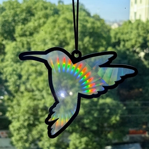 Detail of hummingbird suncatcher showing holographic rainbow effects in natural sunlight