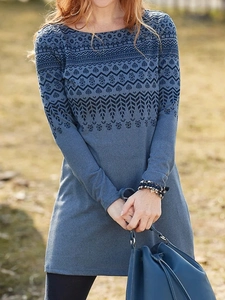 Detail of bohemian leaf patterns and geometric prints on a blue long sleeve dress