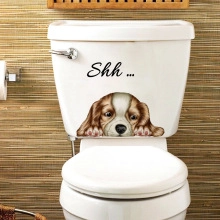 Close-up of a dog sticker on a white toilet tank featuring a King Charles Spaniel with Shh text