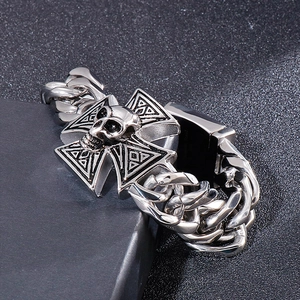 Macro shot of stainless steel gothic cross and skull links on heavy Cuban chain