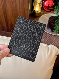 Detailed view of Christmas tree nail stickers YT59 held in a cozy festive setting