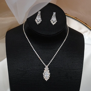 Detailed view of silver necklace and marquise earrings on black velvet display