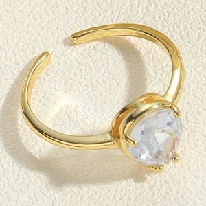 Close-up of golden adjustable ring featuring a faceted pear-cut clear crystal stone