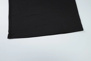 Close-up of double-stitched hem and black knitted fabric texture on summer outfit set