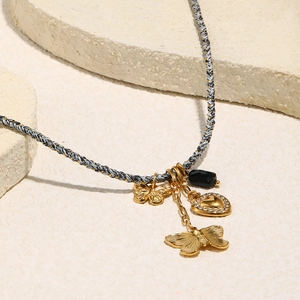 Collana placcata oro 18 carati con ciondoli a farfalla e cuore con pietra nera preziosa