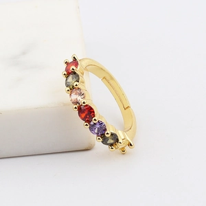 Detalle de piedras de circonita coloridas engastadas en un anillo ajustable dorado
