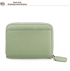 Dettaglio del portafoglio in pelle martellata verde chiaro con zip argentata e cuciture fini