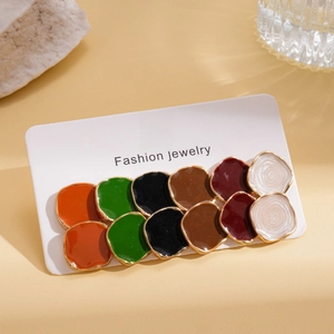 Detail of 12-pair colorful enamel earring set displayed on jewelry card with props
