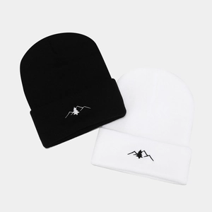 Black and white knit beanies featuring minimalist mountain embroidery and folded cuff