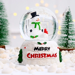 Macro d'une boule de Noël avec bonhomme de neige et socle marqué Merry Christmas