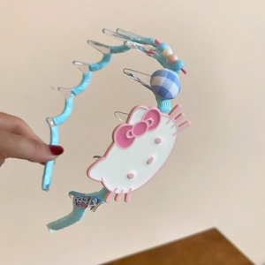 Macro shot of light blue wavy fabric headband featuring cute cartoon kitty and beads