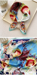 Detailed view of silk scarf featuring traditional blue and red pattern with deer and clouds