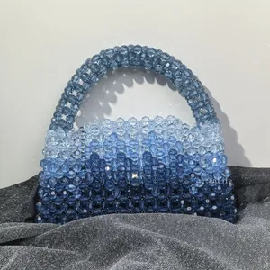Macro shot of handmade beaded handbag with blue gradient beads and woven handle