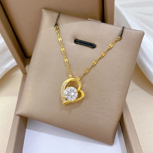 Close-up of a heart pendant necklace with shimmering crystals in a gold jewelry box