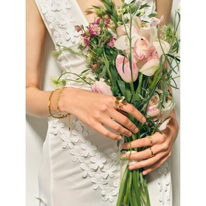 Detail of 18k gold plated stainless steel daisy ring and twisted rope chain bracelet
