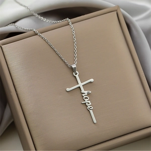 Close-up of silver cross pendant with hope letter engraving on a leather jewelry box