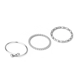 Close-up of three-piece silver stainless steel ring set including leaf and bead designs