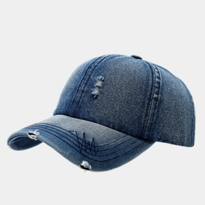 Vue détaillée d'une casquette en denim bleu vintage avec effet délavé et détails déchirés