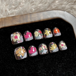 Handmade press-on nails for kids with hand-painted floral and heart patterns in a gift box