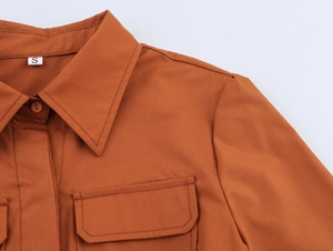 Détail du col de chemise caramel avec revers, poche poitrine et étiquette de taille S