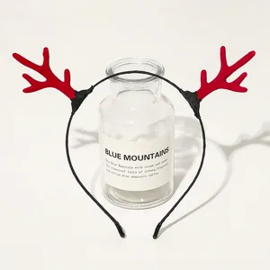Detail of Christmas reindeer antler headband with plush red texture and black frame