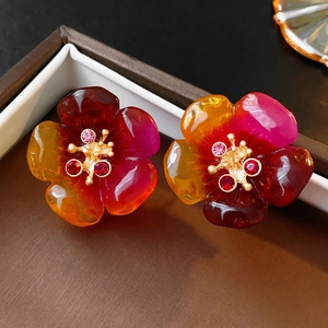 Détail macro de boucles d'oreilles fleur vintage avec pétales dégradés et cristaux