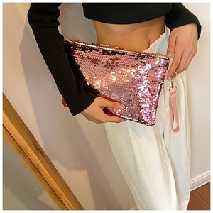 Detailed shot of pink sequin mini clutch bag with zip closure and matching wrist strap