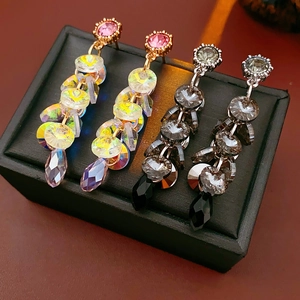 Detailed close-up of crystal tassel earrings in gold and silver with teardrop beads