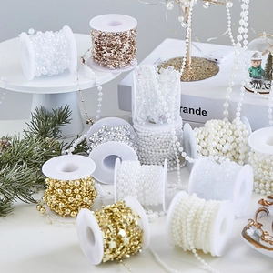 Variety of pearl and star bead chains on spools for Christmas tree decoration and DIY crafts