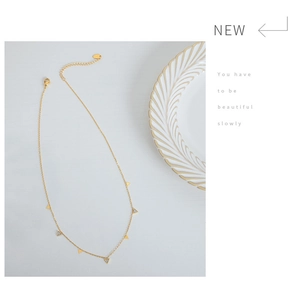 Macro detail of gold-plated titanium necklace featuring minimalist triangle pendants