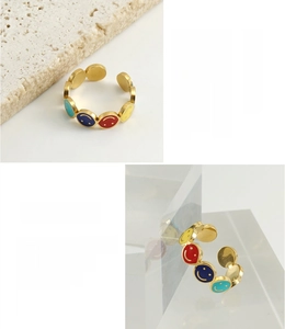 Detailed macro view of colorful enamel smiley faces on 18K gold plated stainless steel ring
