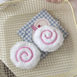 Macro detail of cute white plush fish cake pendants with pink spiral embroidery and bead chains