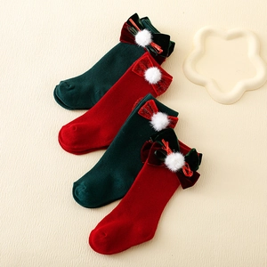 Christmas themed baby knee high socks with velvet bows and pom-poms in red and green