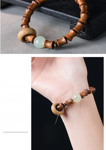 Detail of green sandalwood bamboo-style beads with a pale jade accent on the wrist
