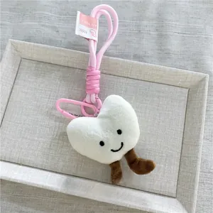 Dettaglio del portachiavi a cuore in peluche bianco con ricamo e moschettone rosa sportivo