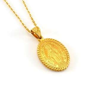 Detail of gold oval religious pendant with Virgin Mary embossed and Latin engraving