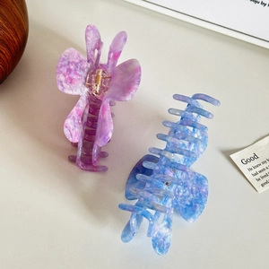 Hollow heart acetate shark hair clips in marble purple and blue colors on white surface