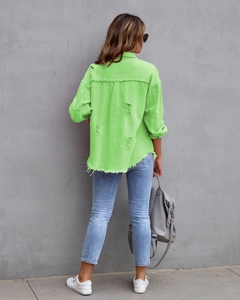 Detail der neongrünen Jeansjacke mit rissigem Rücken und ausgefranstem Saum im Design