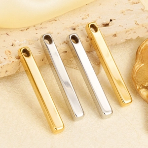 Minimalist long bar pendant charms in gold and silver finish on neutral fabric