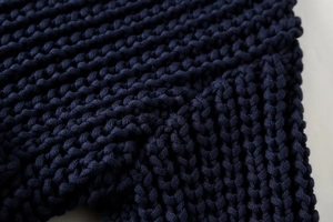 Gros plan sur la maille épaisse et la texture de laine bleu marine d'un pull mode