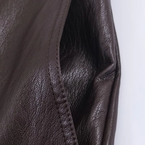 Primer plano de las costuras y textura de cuero sintético marrón de pantalones rectos