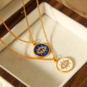 Detail of double-layer gold necklace with blue and white enamel evil eye pendants