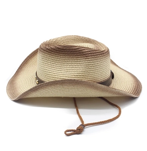 Dettaglio di cappello da cowboy in paglia intrecciata con sfumatura e fascia in pelle