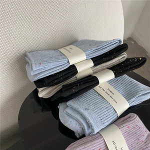 Detail of colorful nep yarn cotton socks in multiple colors with branded paper bands