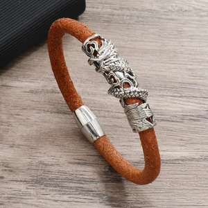 Close-up of brown leather woven bracelet with silver dragon bead and magnetic buckle