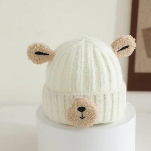 Detailed view of cream-white knitted baby hat featuring cute plush bear ears and embroidery