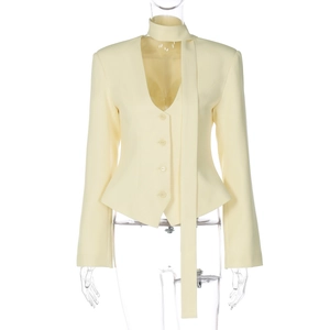 Detail of light yellow slim fit blazer with matching scarf neck design and button closure