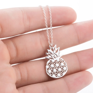 Detail of silver hollow pineapple pendant necklace being held to show size and scale